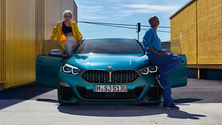 BMW 2 Series Gran Coupé F44, front view BMW 2 Series Gran Coupé F44 Snapper Rocks Blue, front view with open doors and two people at the vehicle