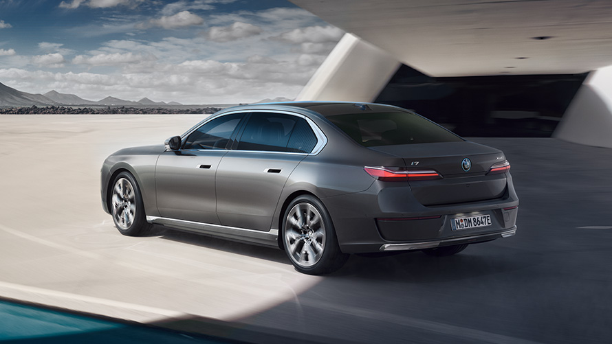 BMW i7 Sedan package 3/4 rear view BMW i7 Sedan G70 BMW Individual Oxid grey metallic 3/4 rear view standing in front of building