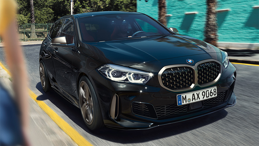 BMW M135i xDrive (F40) in Black Sapphire metallic, three-quarter front view driving