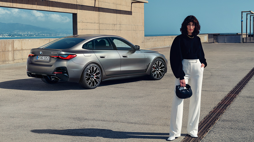BMW M440i xDrive Gran Coupé G26 2021 three-quarter rear view with model BMW M440i xDrive Gran Coupé G26 2021 Frozen Pure Grey metallic three-quarter rear view with model