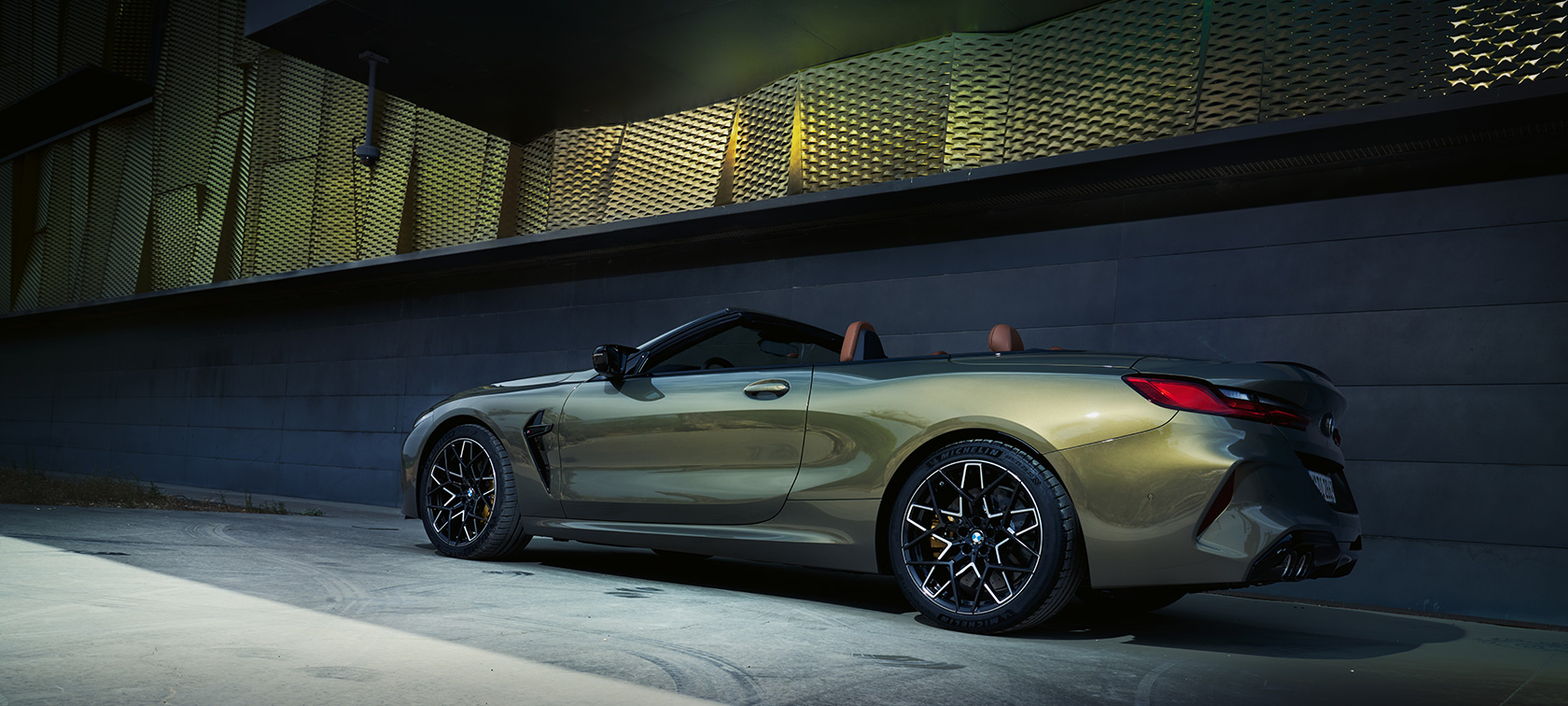 BMW M8 Competition Convertible F91 LCI Facelift 2022 BMW Individual Brass metallic three-quarter side view standing in front of a wall