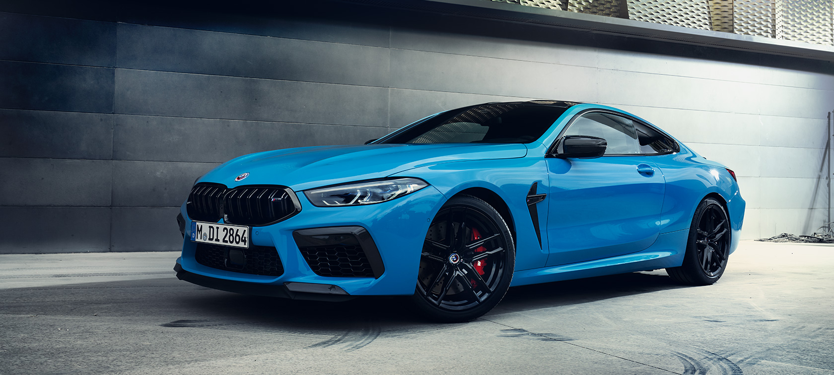 BMW M8 Competition Coupé F92 LCI Facelift 2022 Daytona Beach Blue uni three-quarter side view standing in front of a wall