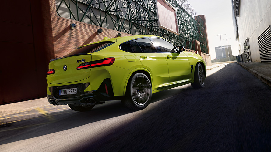 BMW X4 M Competition F98 LCI Facelift 2021 Sao Paulo Yellow three-quarter front view driving between factory buildings