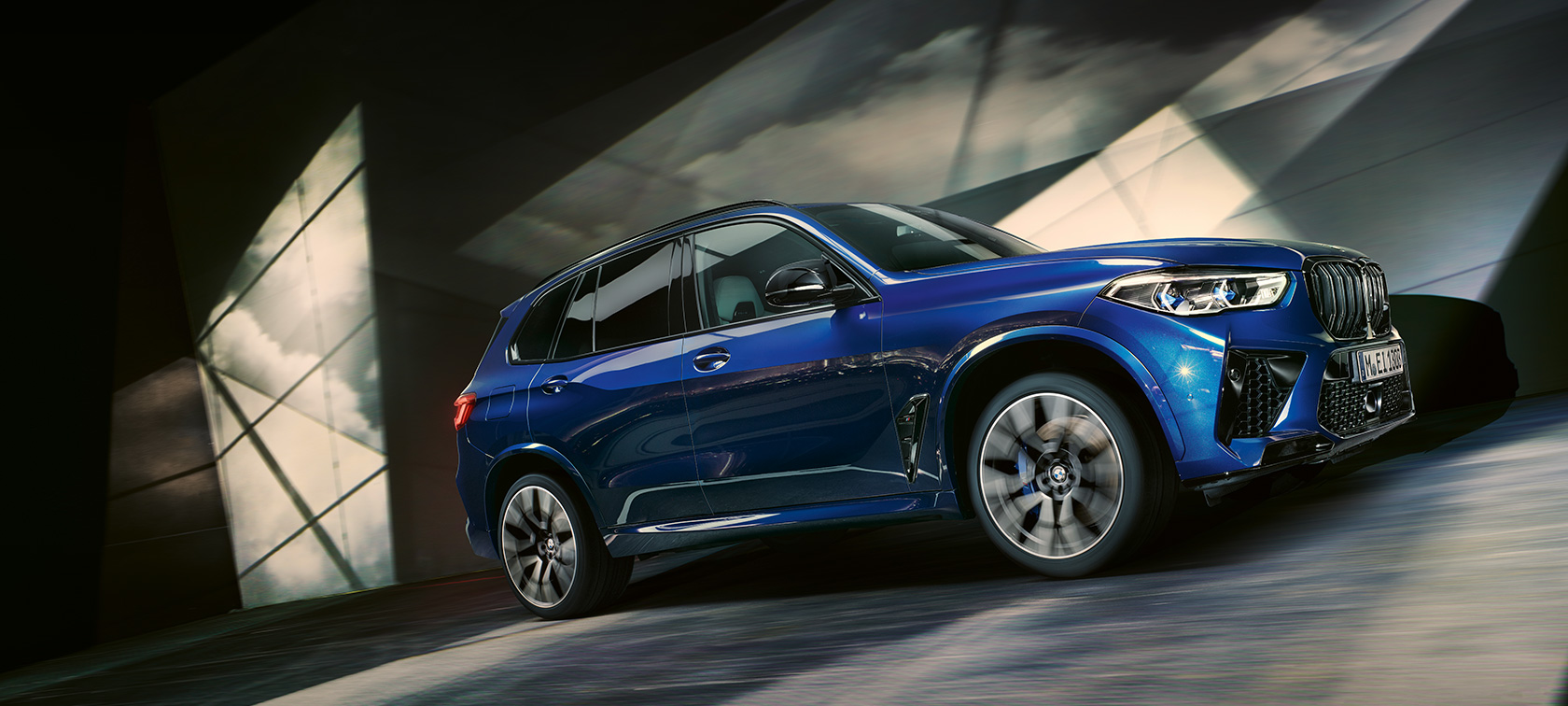 BMW X5 M Automobiles F95 2020 SUV BMW X5 M Competition Marina Bay Blue metallic three-quarter side view low-angle shot driving