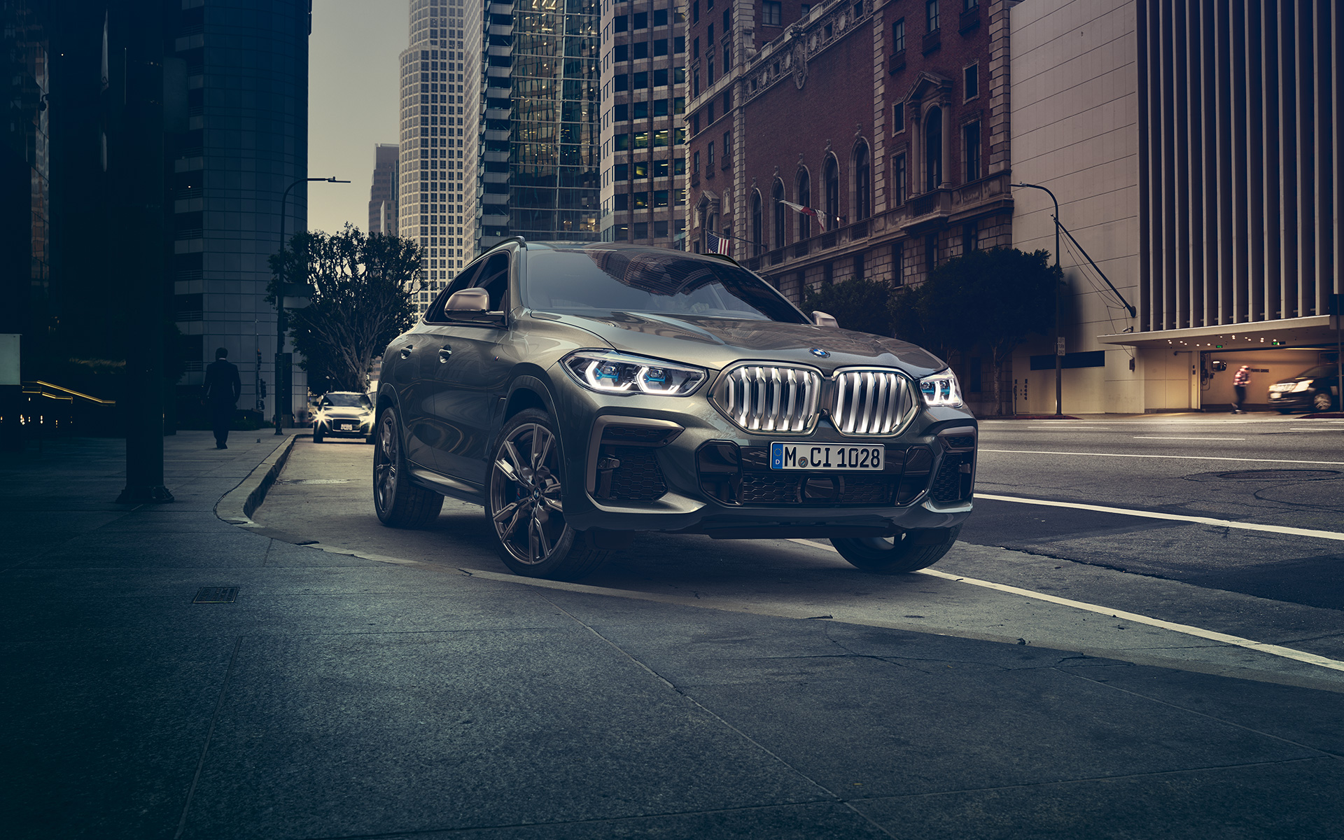 BMW X6 M50i in three-quarter front perspective standing in front of an urban setting G06 2018 SUV