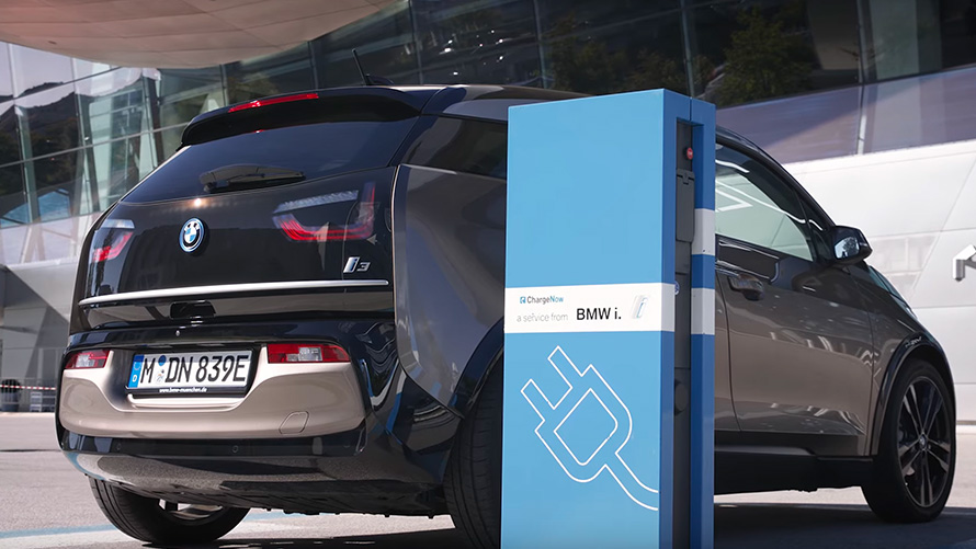 BMW i3 on charging station three-quarter rear view 