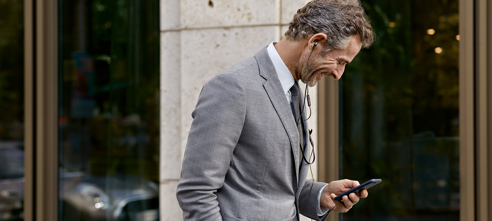 BMW, Controlling Costs: A man is looking at his smartphone